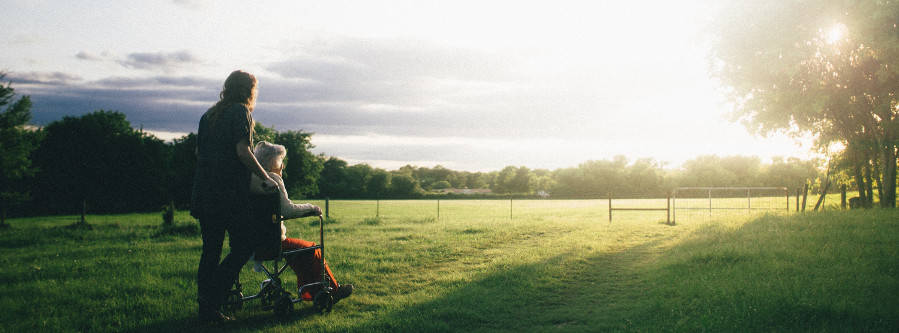 woman standing next to woman riding wheelchair